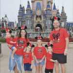 a family posing for a picture in front of a castle